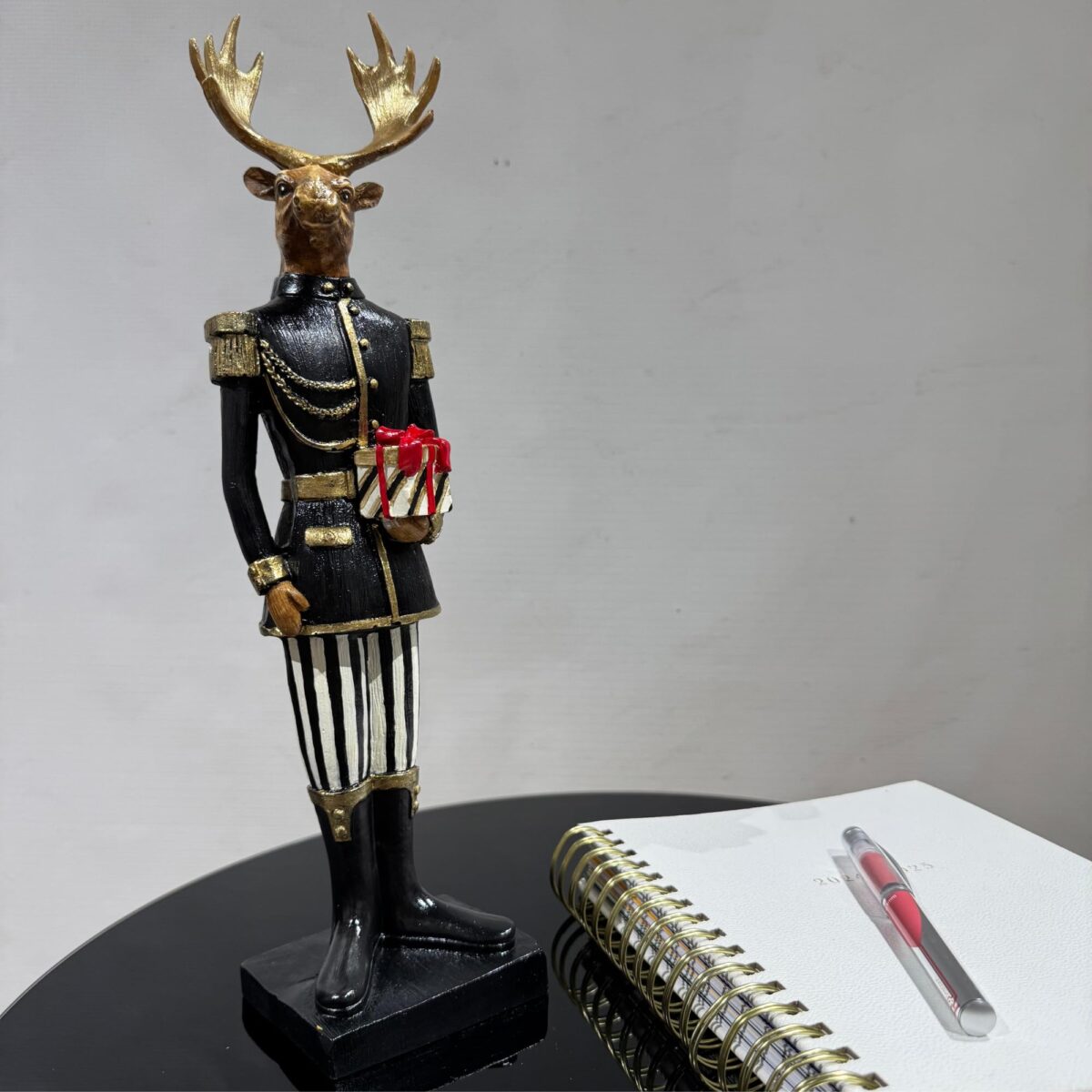 Vibrant Black Jacket Deer Holding a Gift Box Sculpture