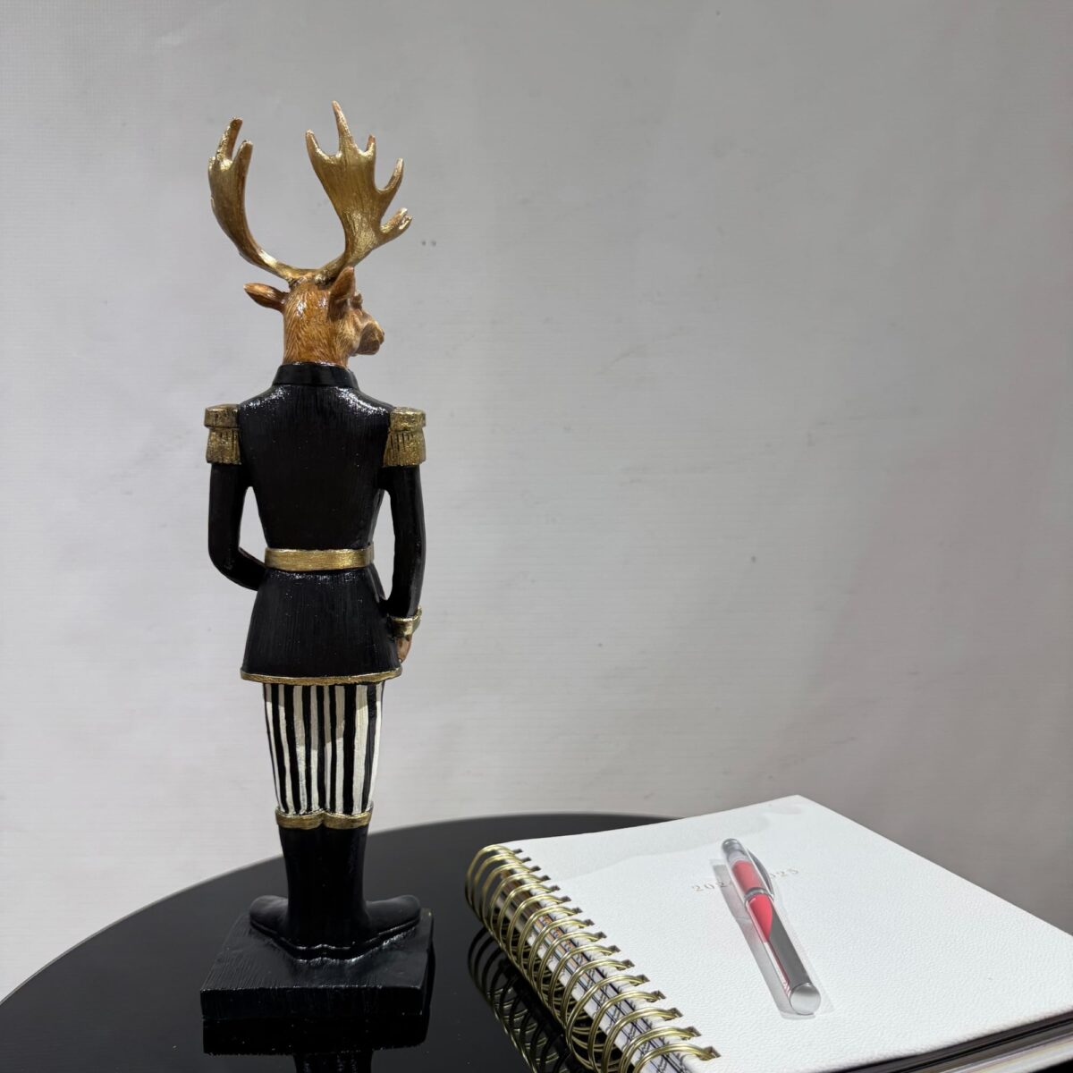 Vibrant Black Jacket Deer Holding a Gift Box Sculpture